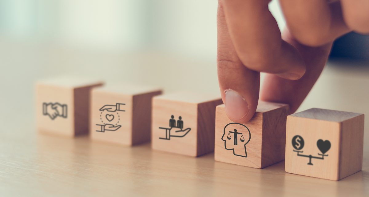 Business ethics concept. Ethics inside human mind. Business integrity and moral. Putting wooden cubes with ethics inside a head standing with other ethics icon. Company culture and sustainable success